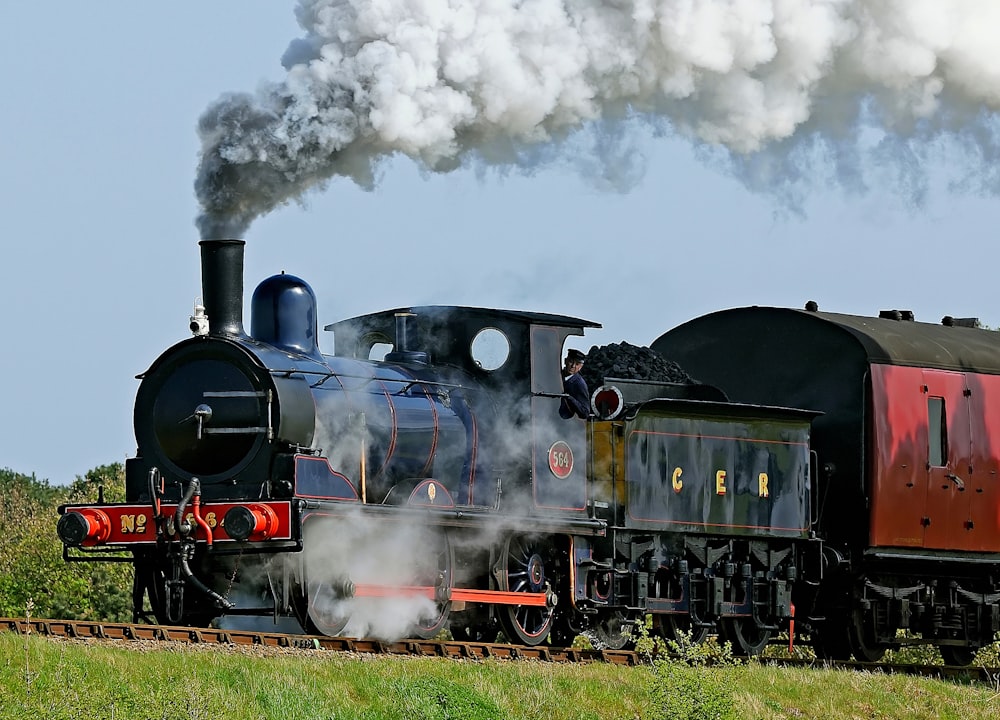 black and red train on rail tracks during daytime