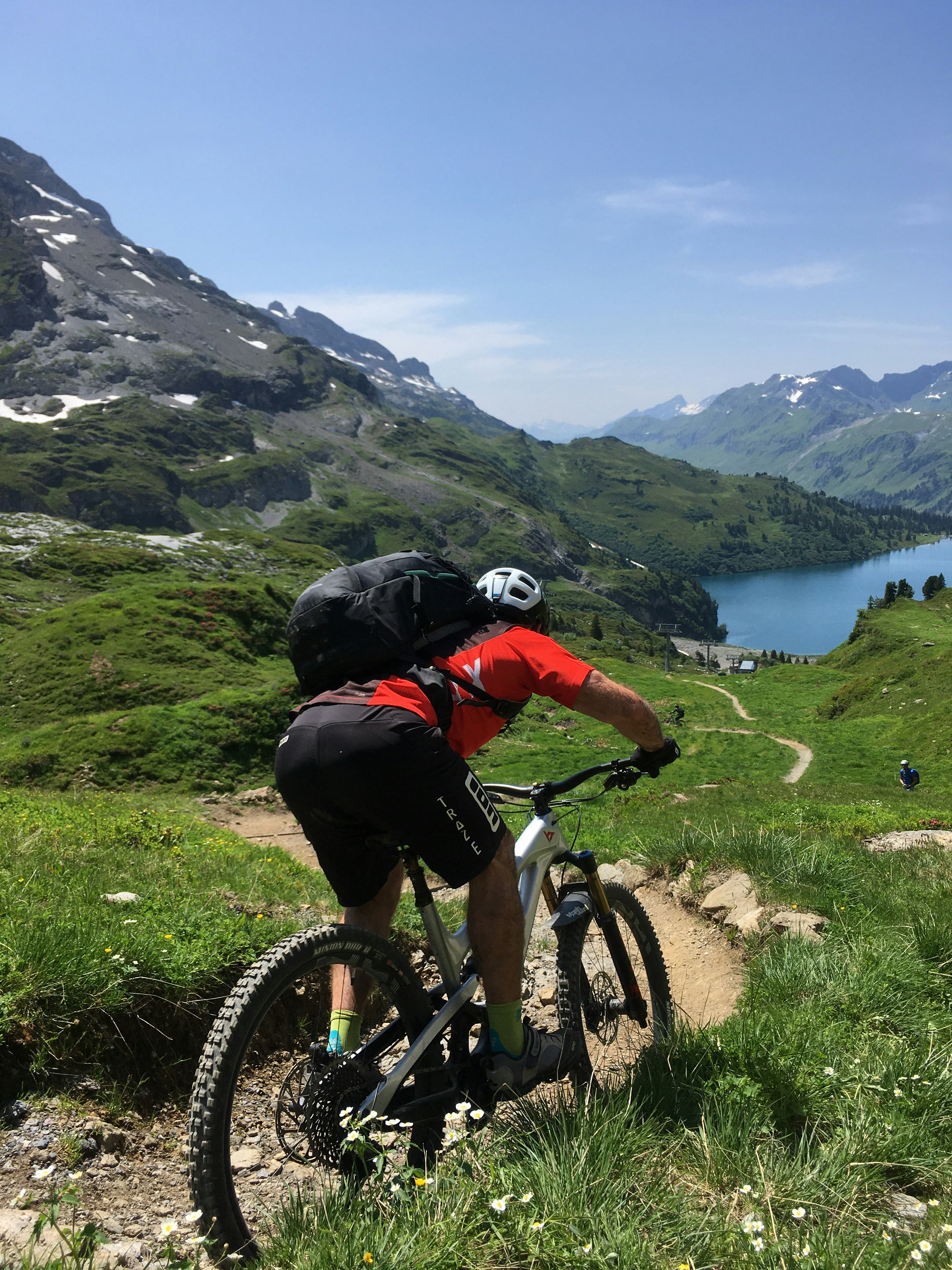 man in black jacket riding on mountain bike during daytime