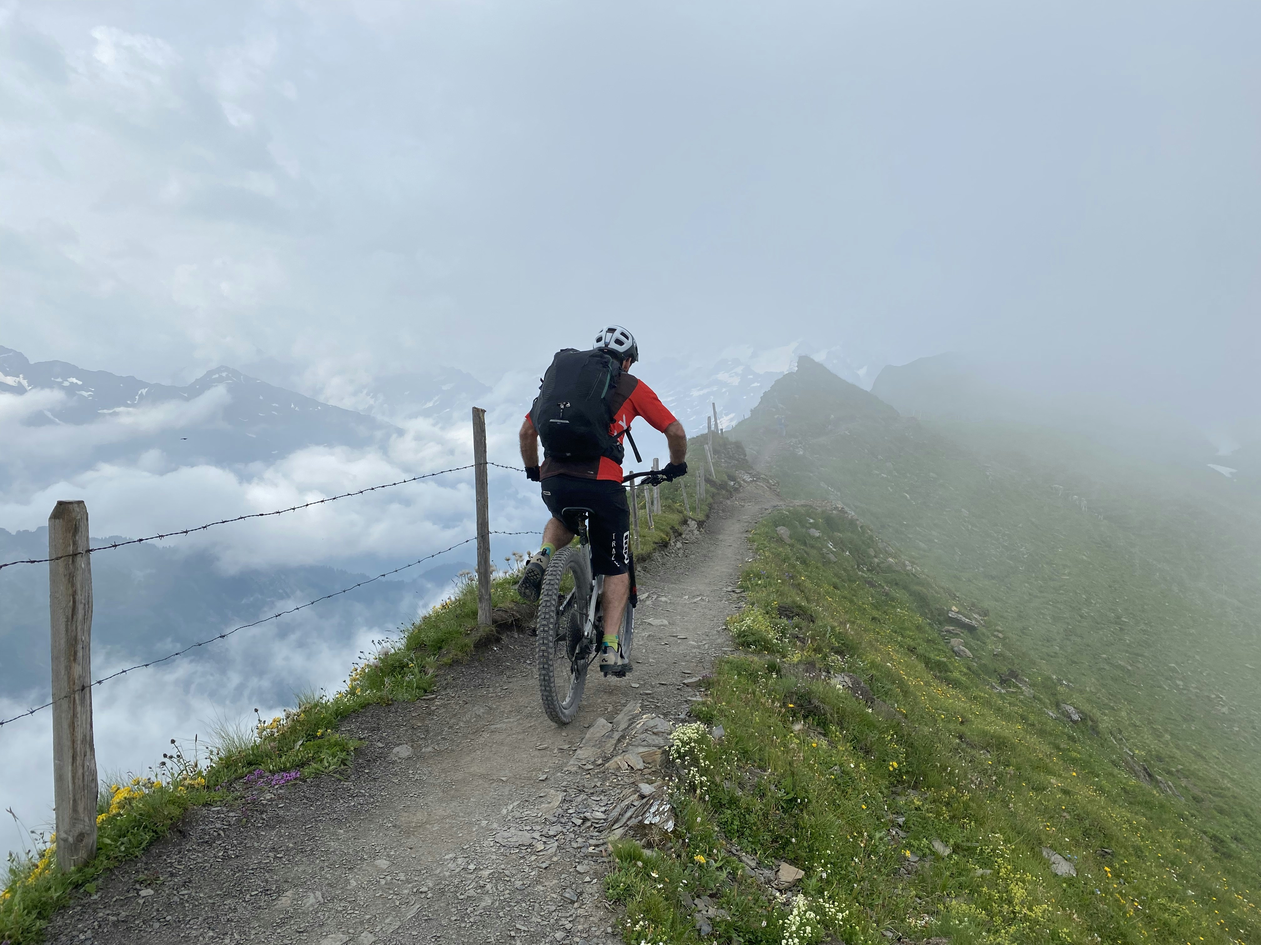 man in black jacket riding bicycle on green grass field during daytime