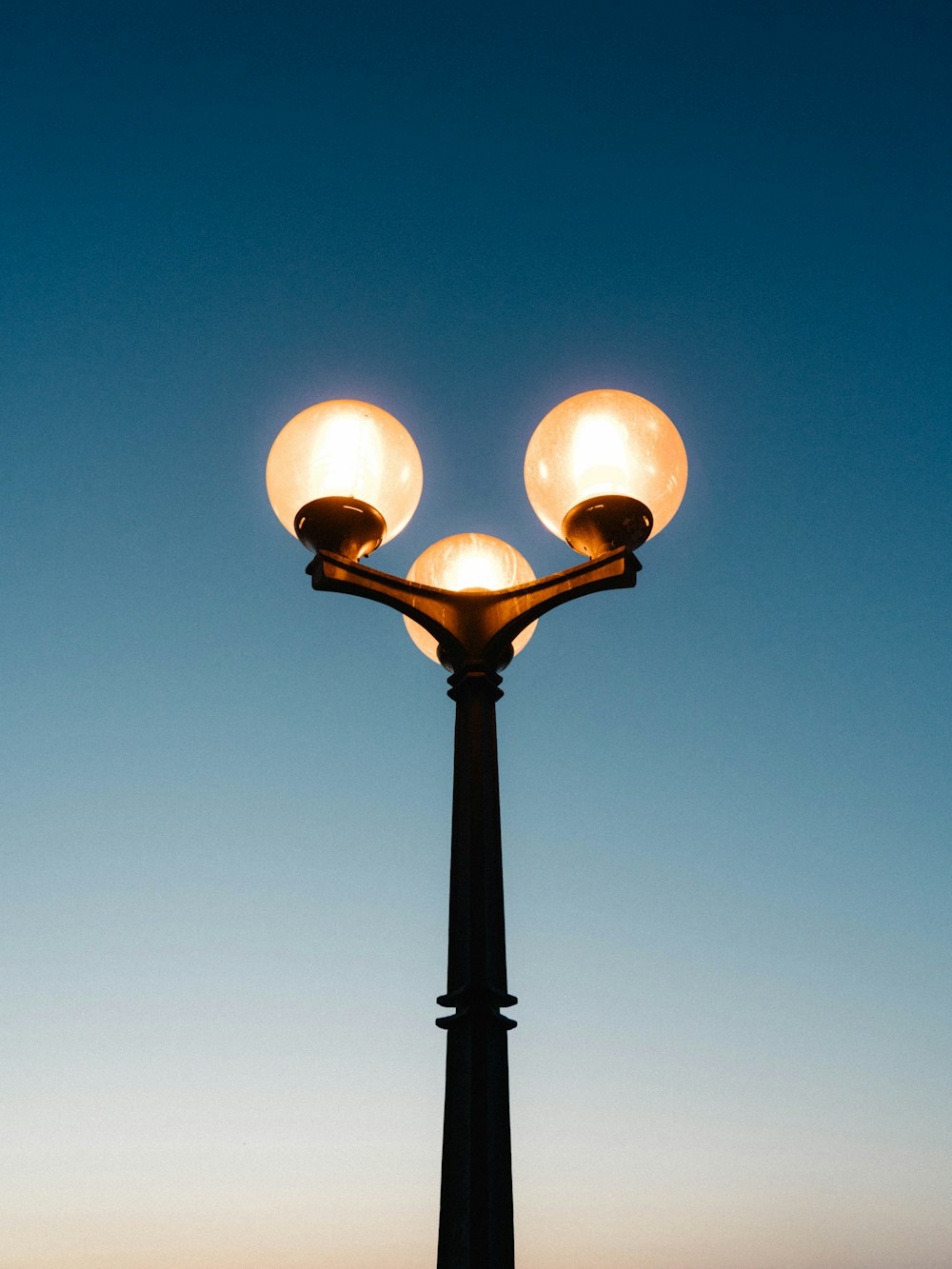 luz de rua preta sob o céu azul durante o dia