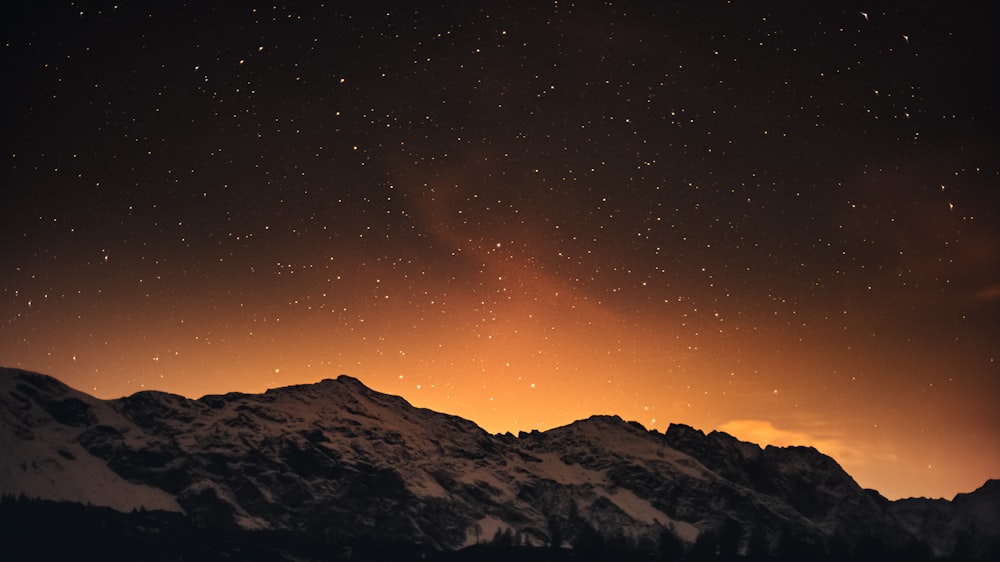 snow covered mountains during night time
