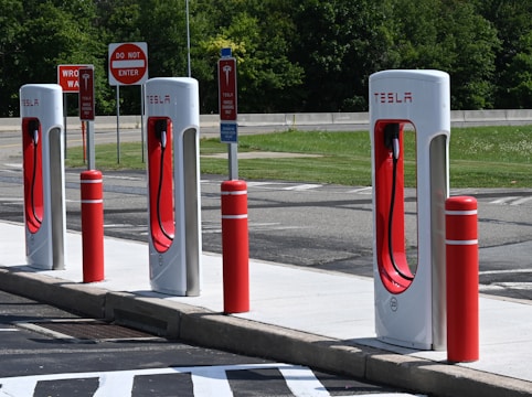 Technicians setting up fast charging equipment at a busy highway rest stop.