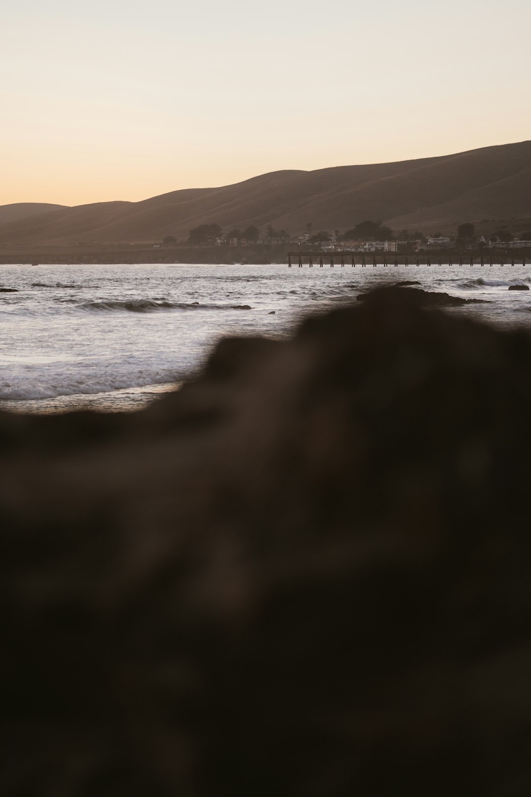 silhouette of mountain near body of water during daytime