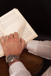 person in white long sleeve shirt holding white printer paper