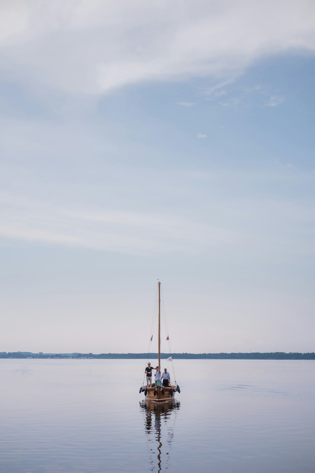 white boat on sea under white sky during daytime