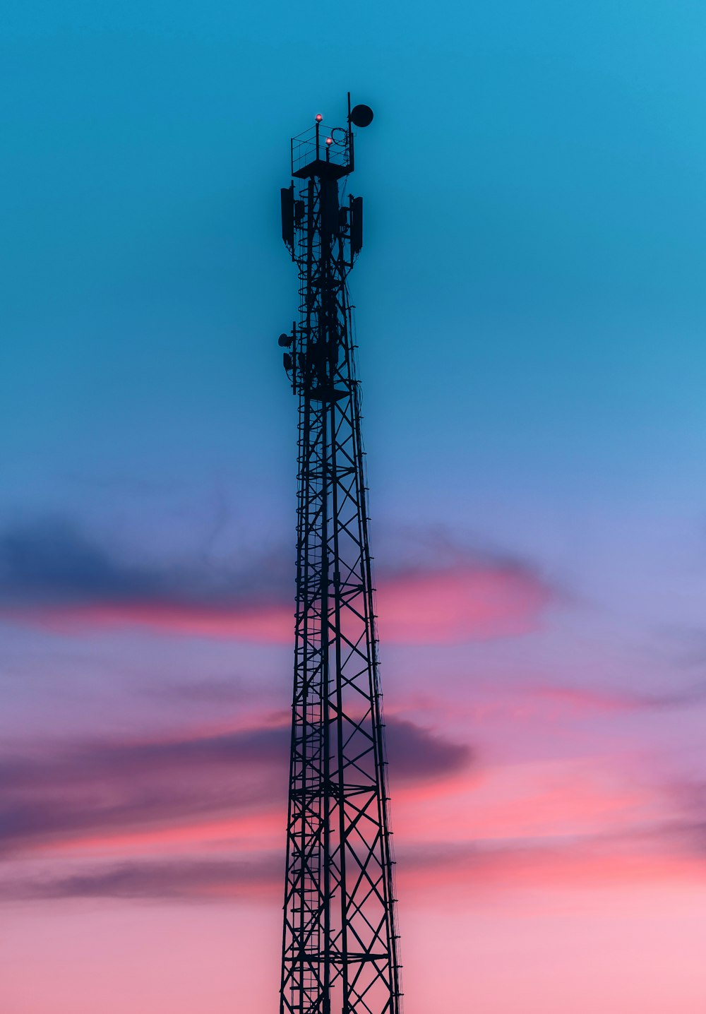 black metal tower under orange and blue sky