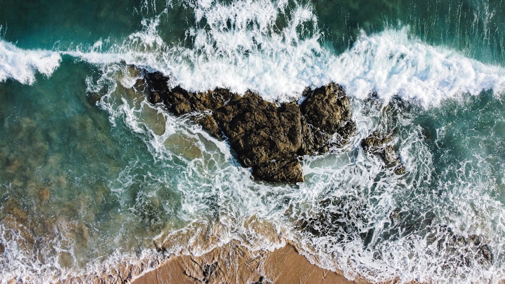 brown rock formation on sea during daytime