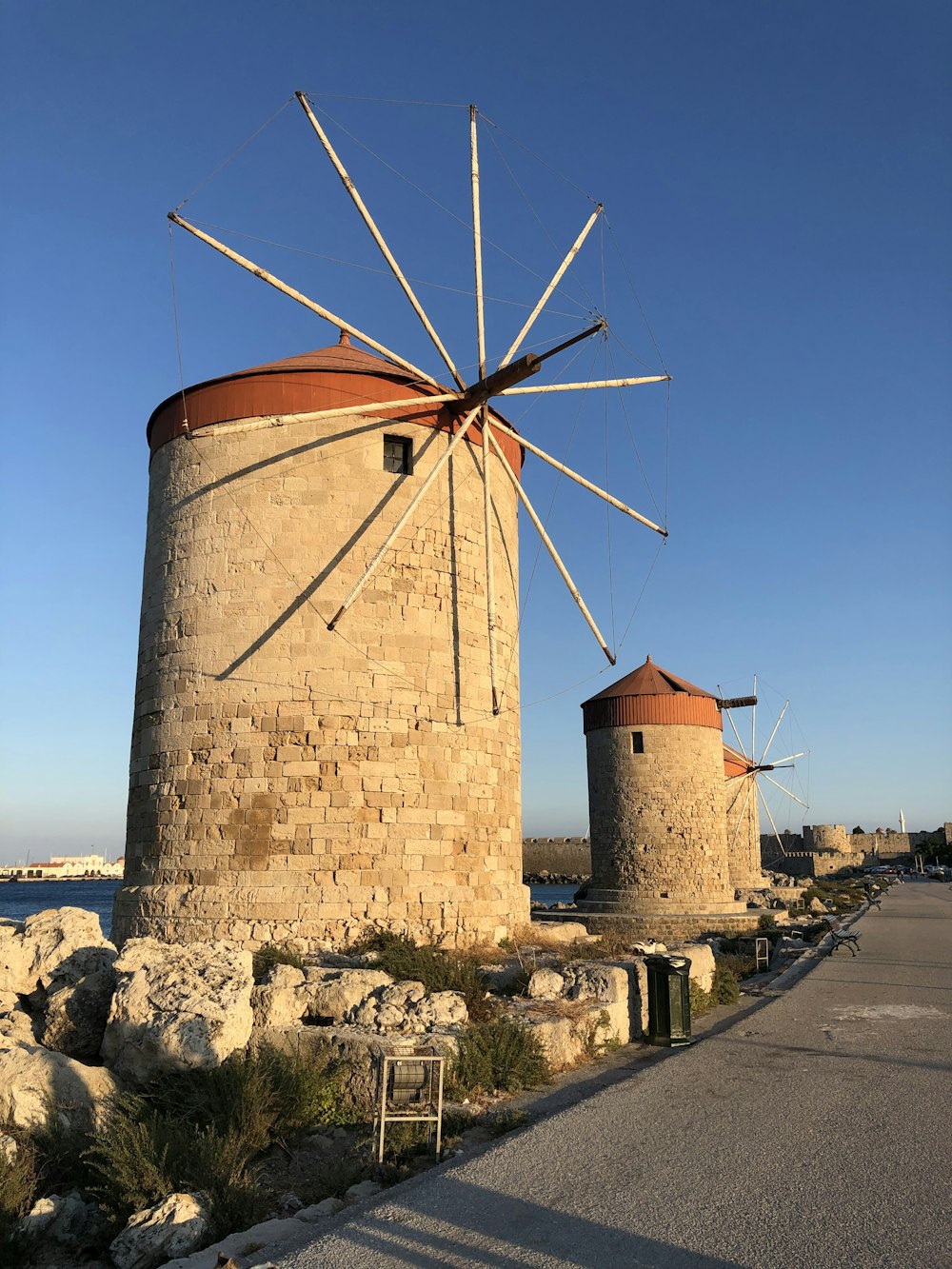 brown windmill near body of water during daytime