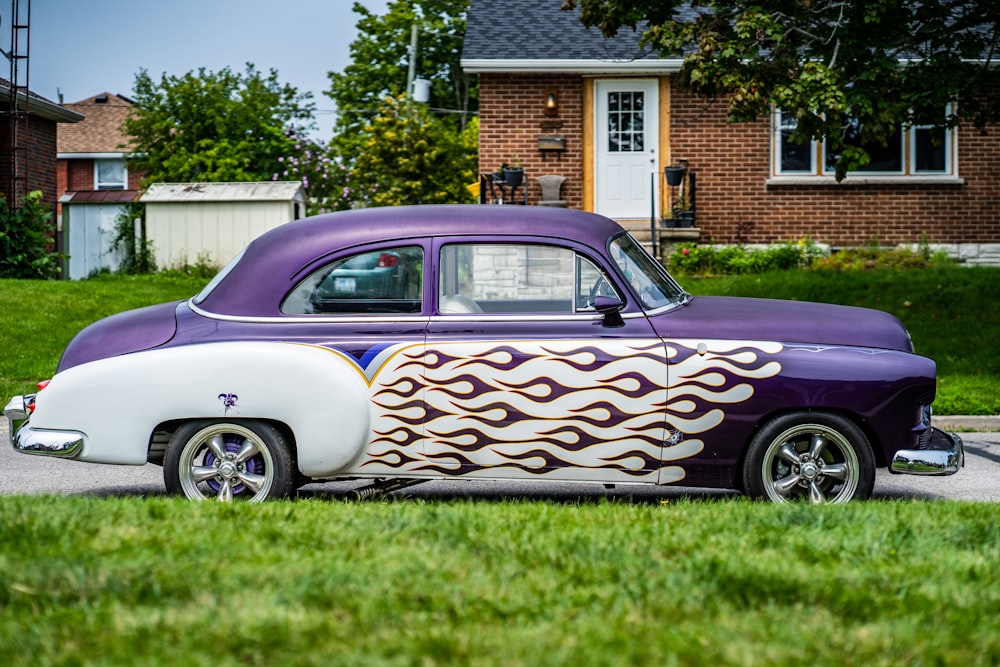 white and purple vintage car on green grass field during daytime