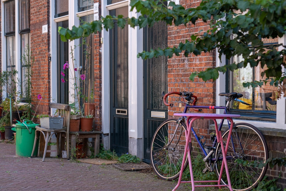 red city bike parked beside green and brown concrete building during daytime