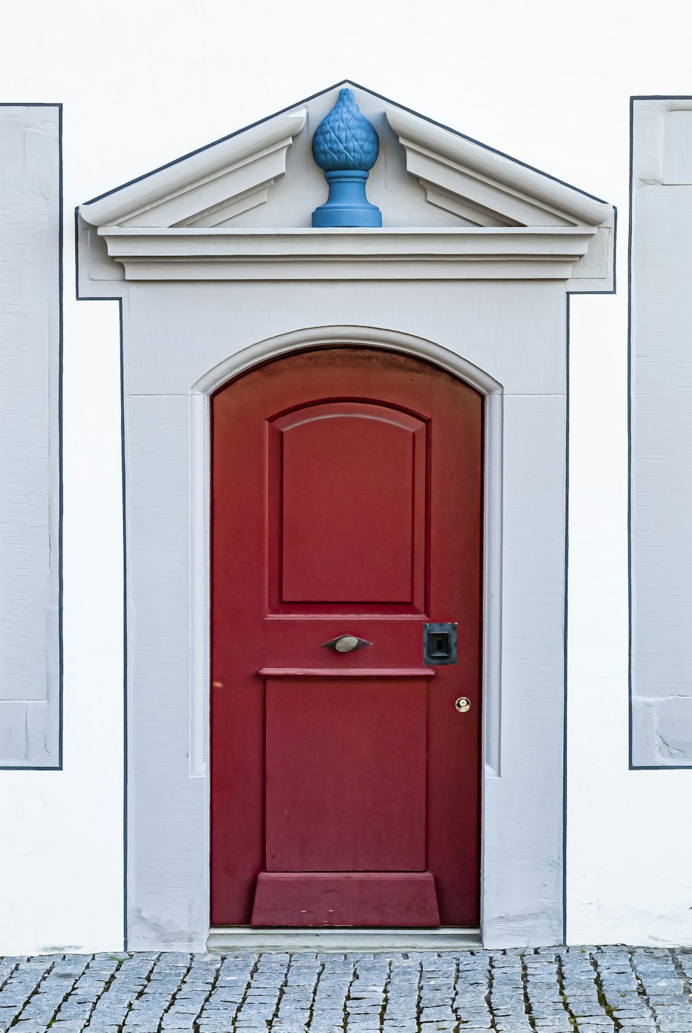 red wooden door beside blue and white lamp