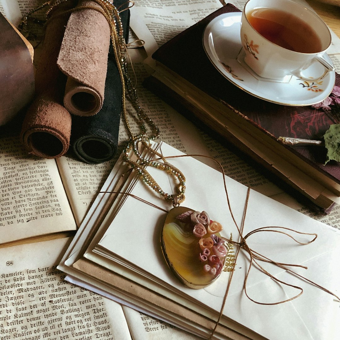 white ceramic mug on white ceramic saucer beside silver necklace