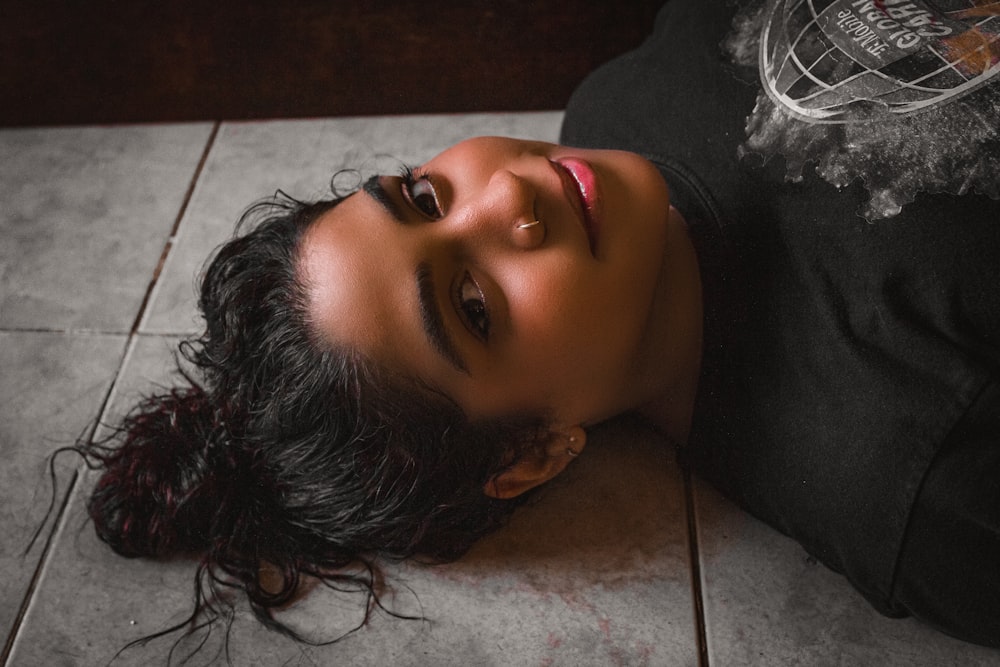 woman in black shirt lying on floor