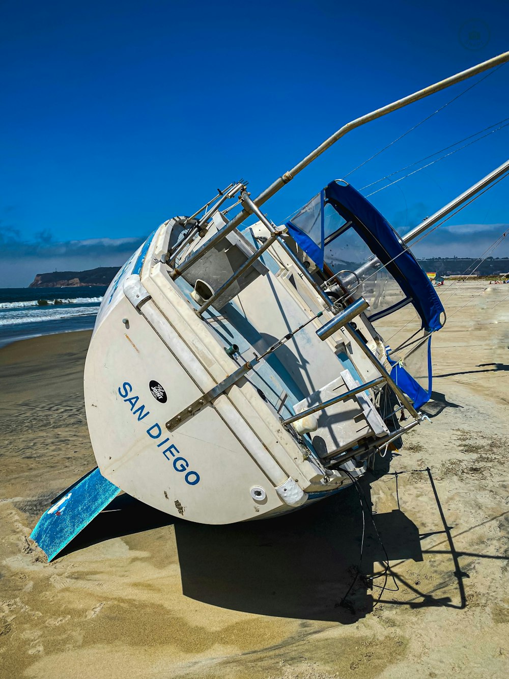 white and blue surfboard on beach during daytime