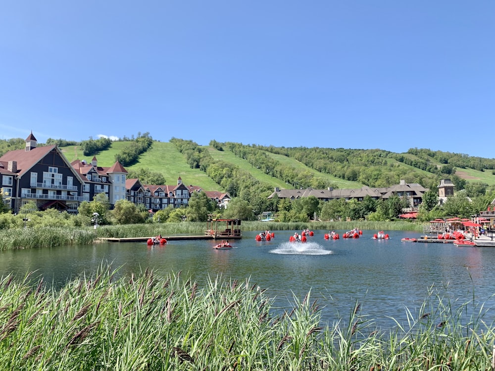 red boat on river near green trees during daytime