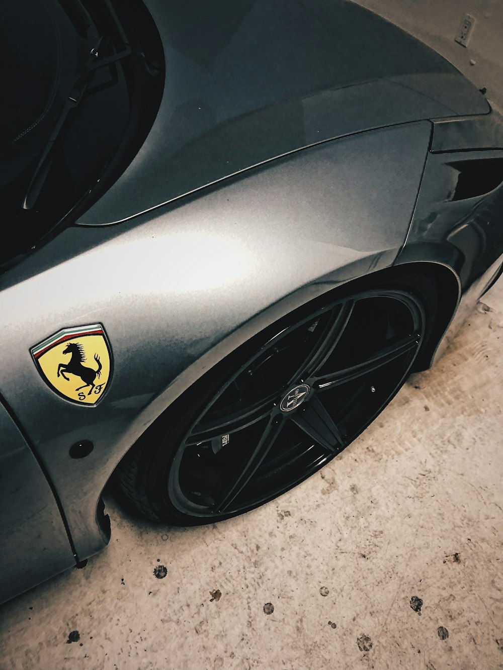 black porsche 911 parked on gray concrete pavement