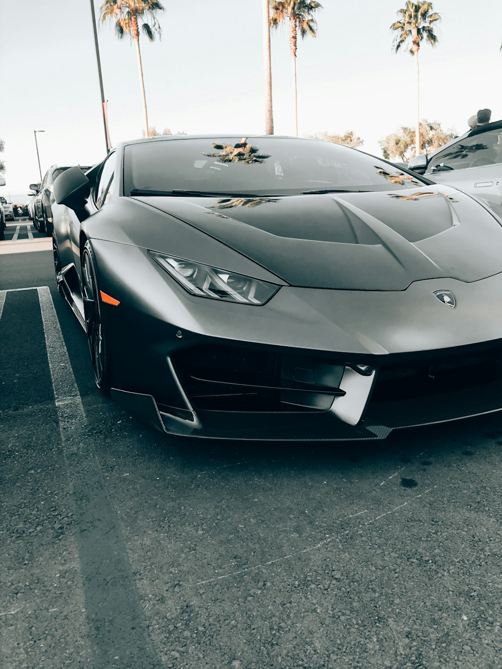 black lamborghini aventador parked on parking lot during daytime