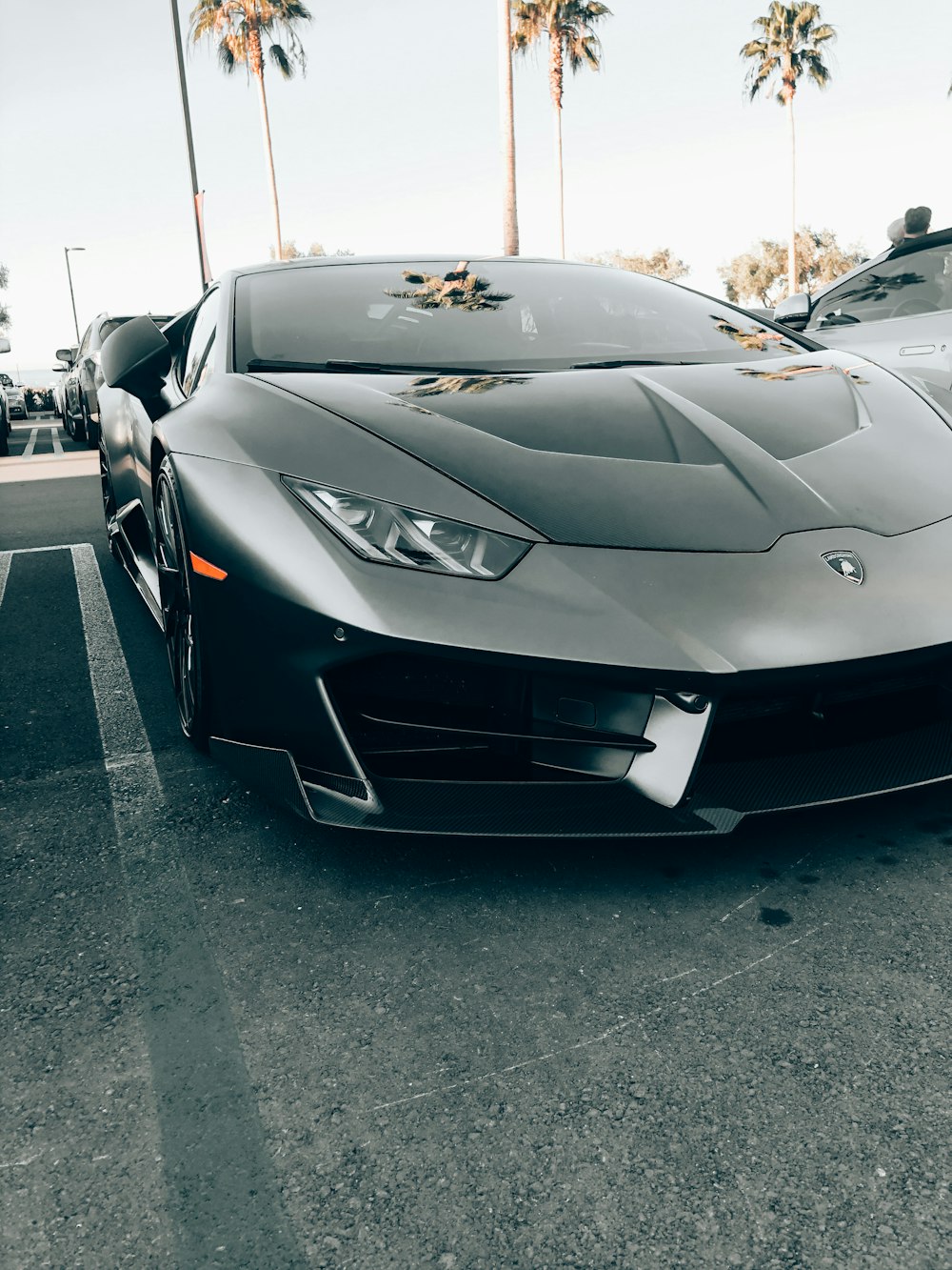 Lamborghini Aventador negro estacionado en el estacionamiento durante el día
