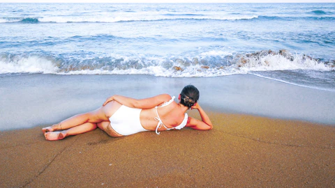 woman in white bikini lying on beach