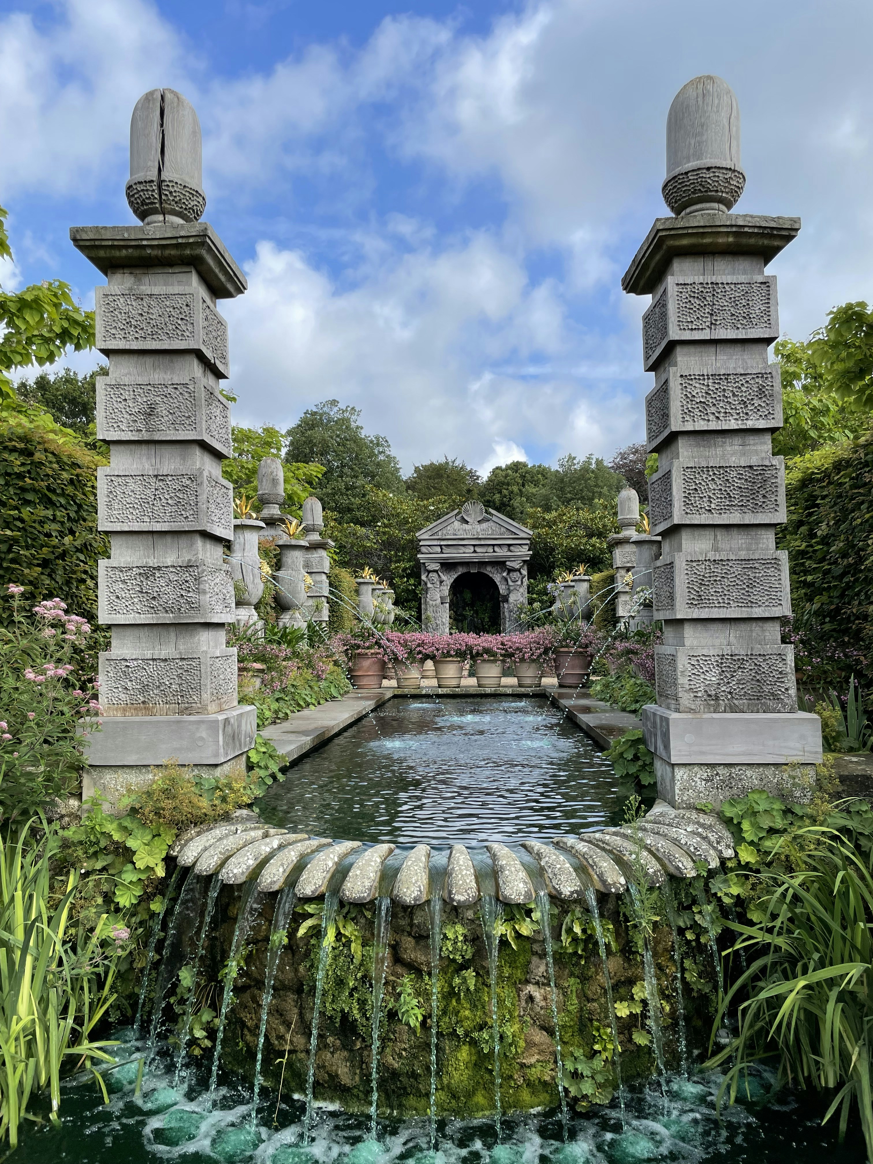 Edificio de hormigón gris cerca de la fuente de agua bajo el cielo azul durante el día