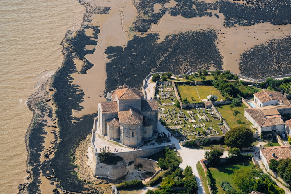 aerial view of white concrete building near body of water during daytime