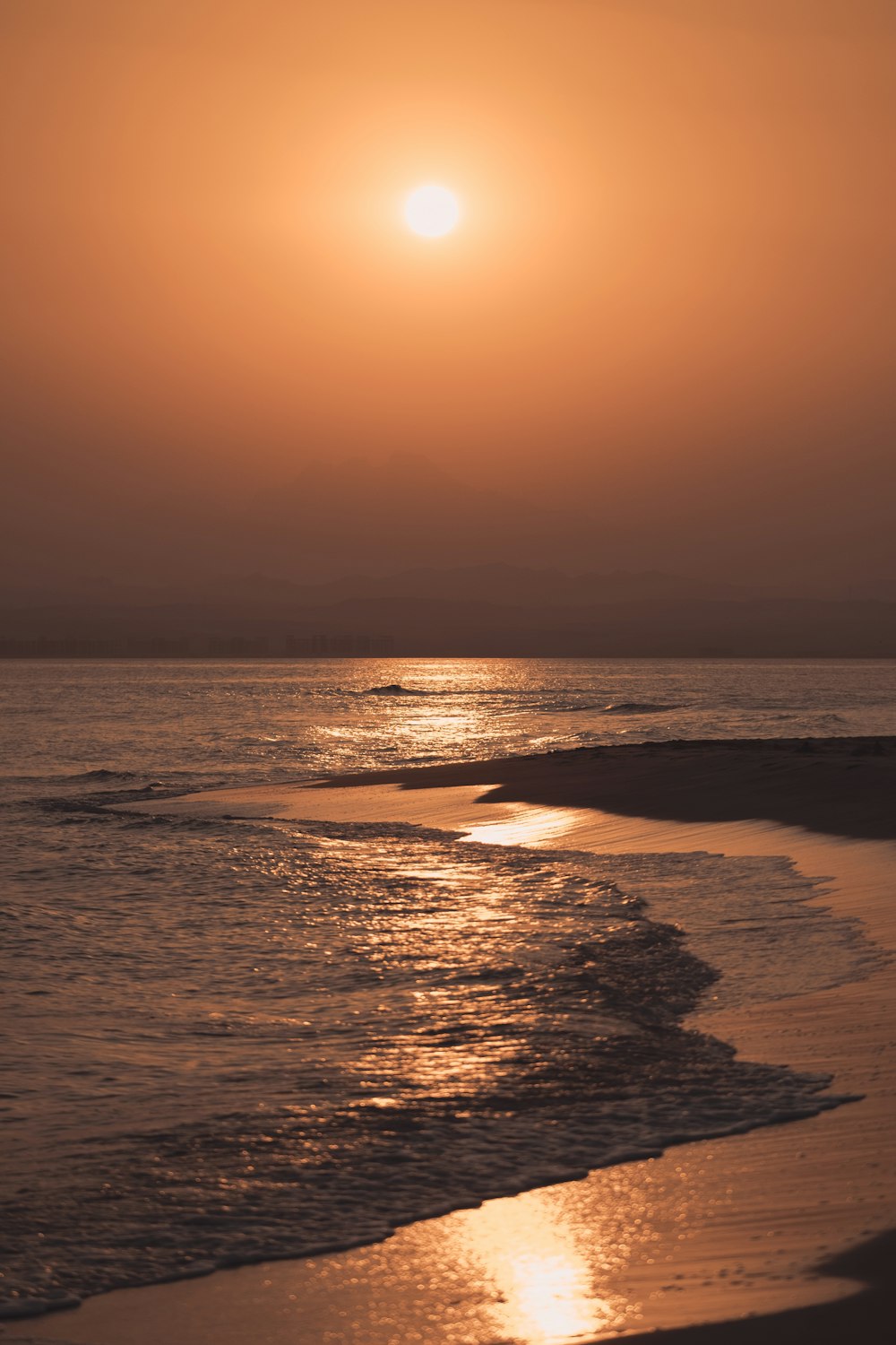 ocean waves crashing on shore during sunset