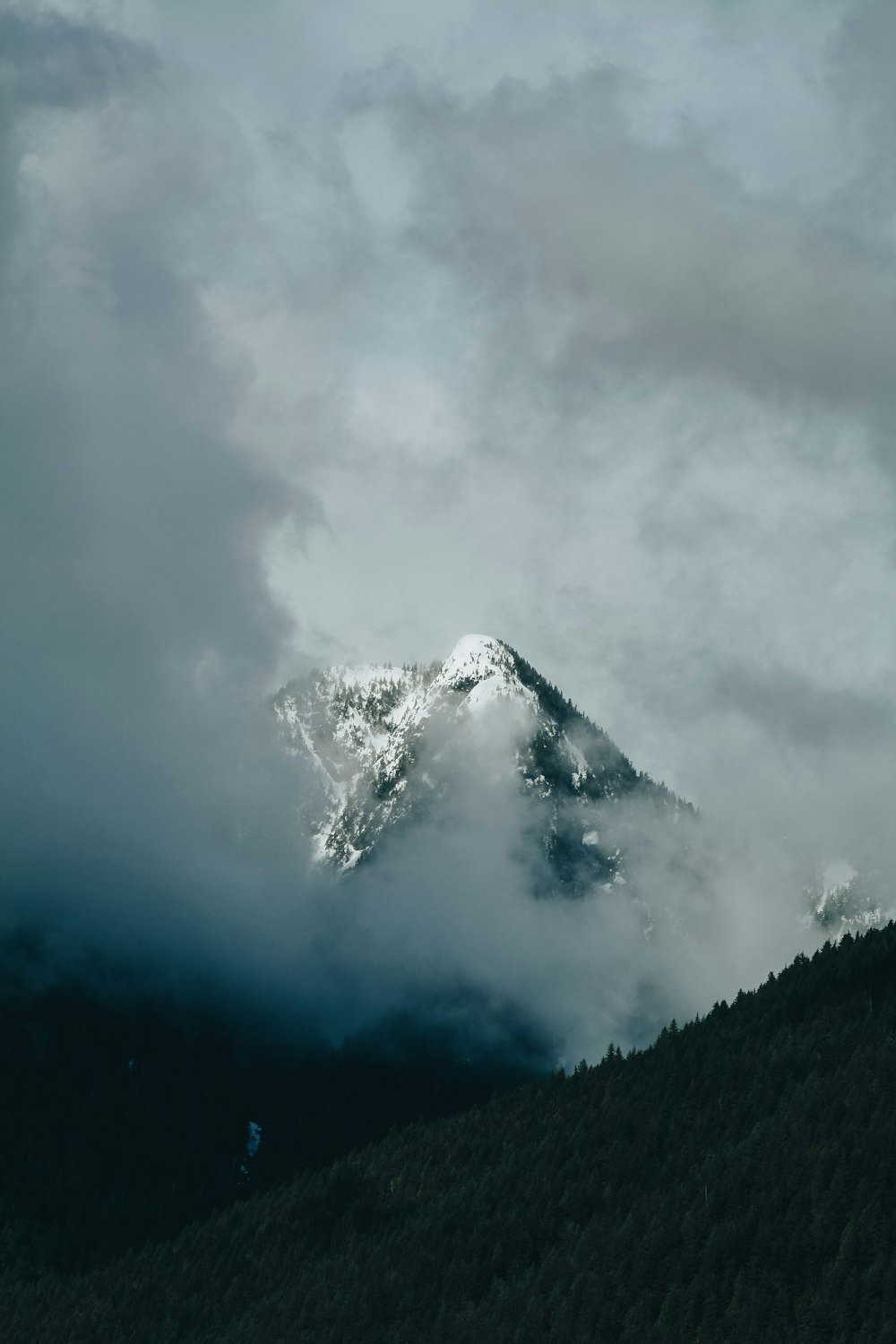 雪に覆われた山の上に白い雲