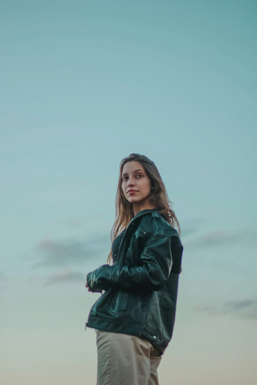 woman in black leather jacket standing under white sky during daytime