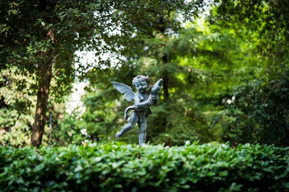 angel statue in the middle of the forest