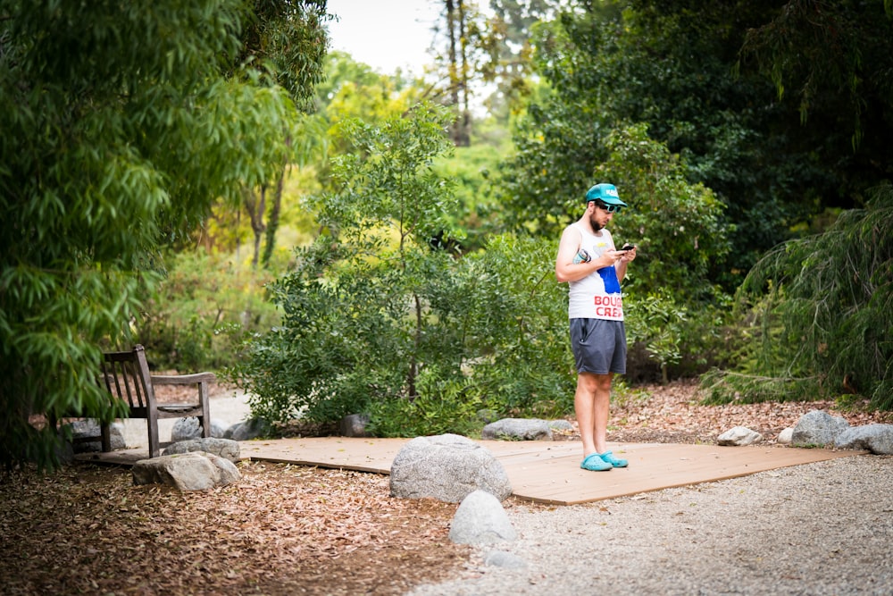 man in blue t-shirt and blue shorts standing on brown soil during daytime