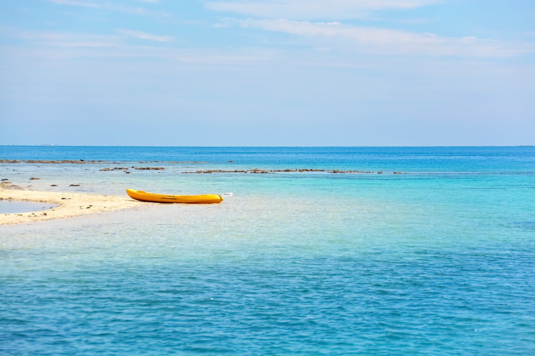 yellow boat on blue sea under blue sky during daytime