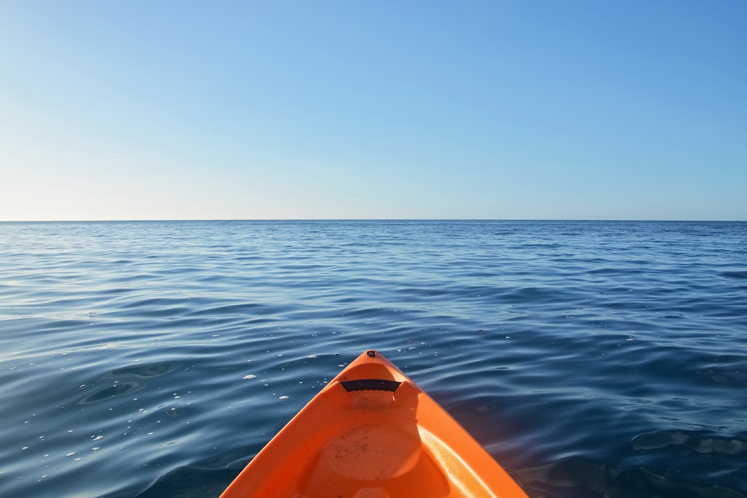 orange kayak on blue sea during daytime