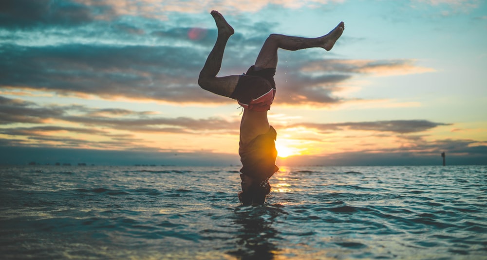 Frau im gelben Bikini springt tagsüber auf Wasser