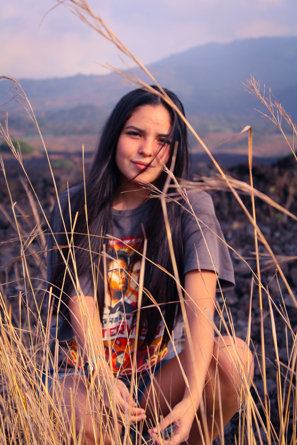 woman in grey crew neck t-shirt standing on brown grass field during daytime