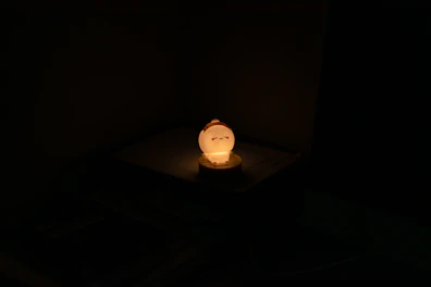 A rechargeable light glowing warmly on a bedside table.
