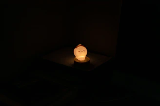 A rechargeable light glowing warmly on a bedside table.