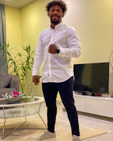 A friendly technician explaining maintenance tips to a homeowner in their living room.