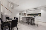 Modern kitchen area with sleek appliances and a small dining table.