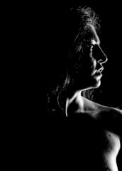 A striking black and white portrait of a model with sharp shadows and sleek styling.