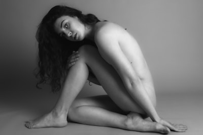 Monochrome image of a model seated, exuding quiet strength and timeless elegance.