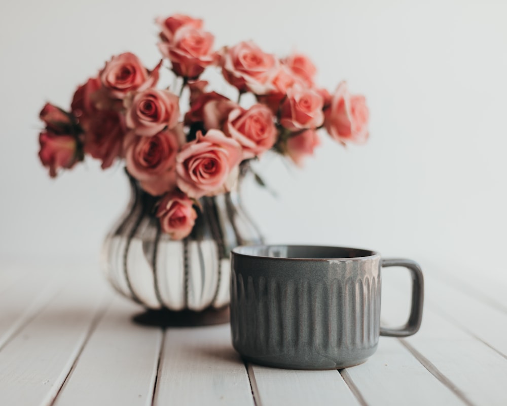 red roses in white and black ceramic vase