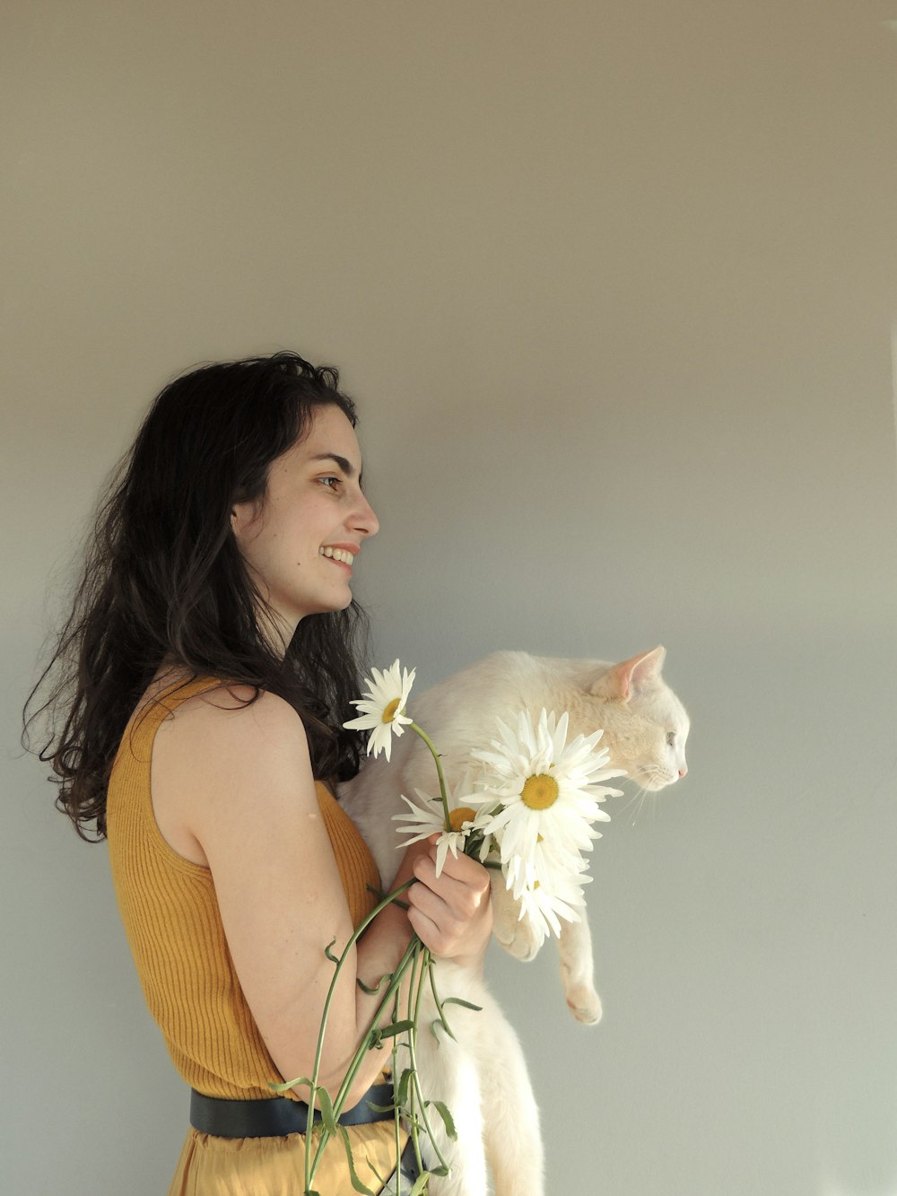 woman in orange tank top holding white flower