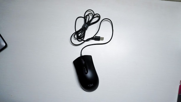 black corded computer mouse on white table