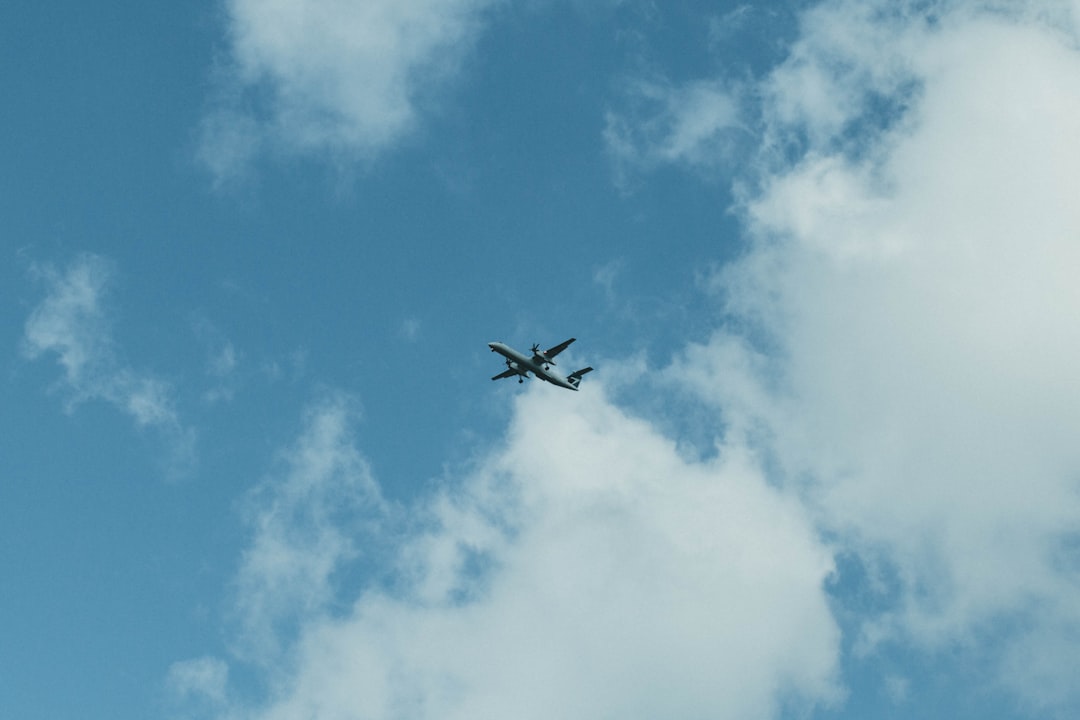 black airplane in mid air under blue sky during daytime
