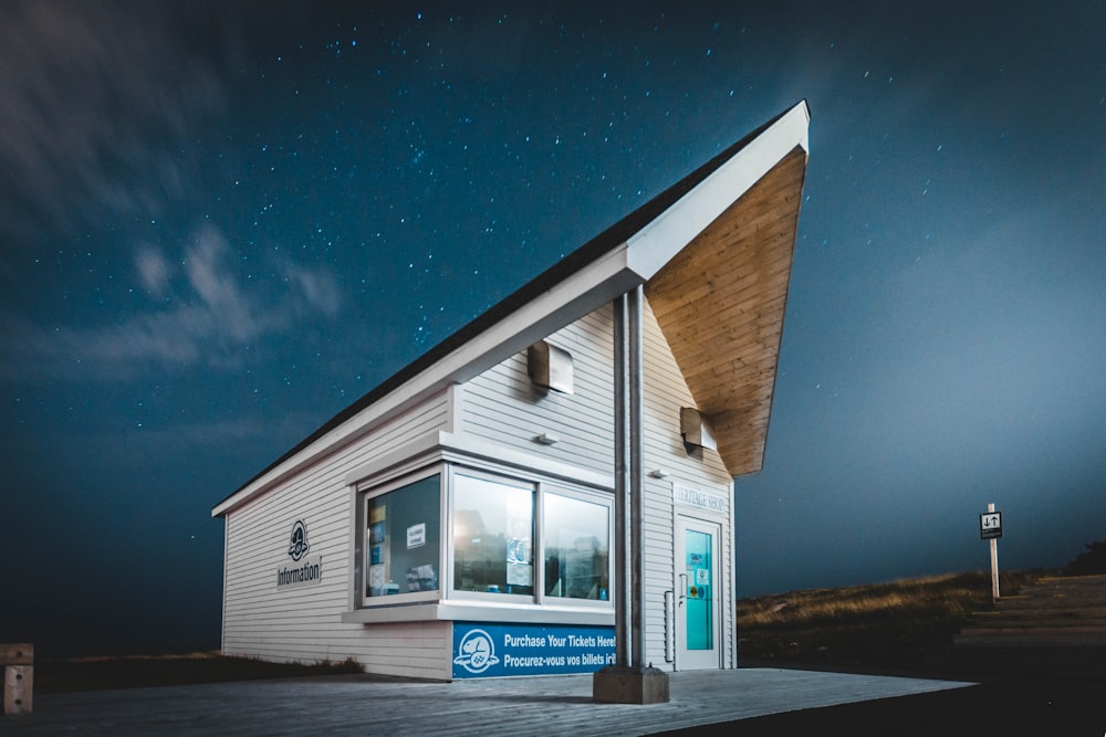 white and brown wooden house near body of water during night time