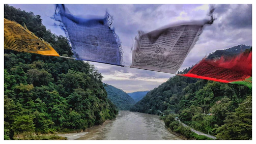 Colorful prayer flags fluttering over a misty mountain valley.