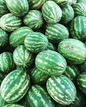 Stacks of watermelons neatly packed for bulk shipment at a warehouse.