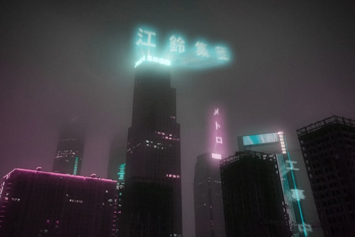 A cityscape at night shrouded in fog, with illuminated skyscrapers displaying neon signs. The fog diffuses the glow from the signs, creating a moody and futuristic atmosphere. The buildings have a mixture of purple and blue neon lights, adding to the cyberpunk aesthetic.