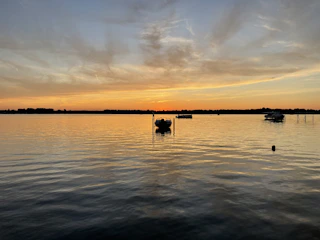 Sunset view over a calm lake with boats.