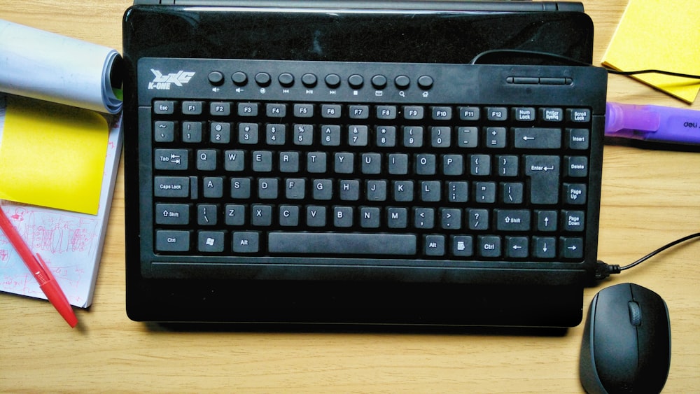 black logitech keyboard on brown wooden table